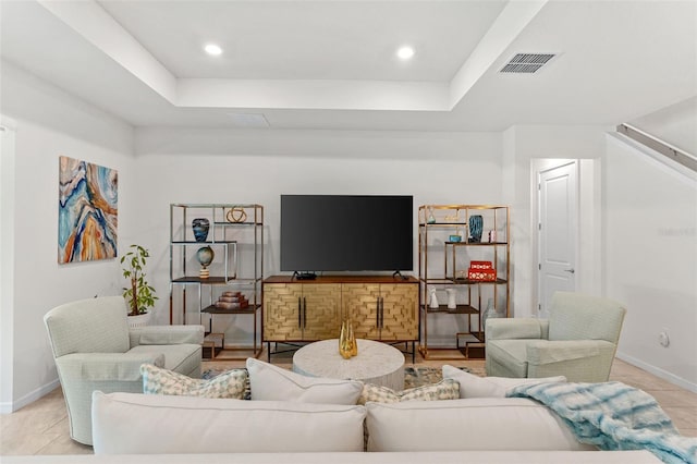 tiled living room featuring a raised ceiling