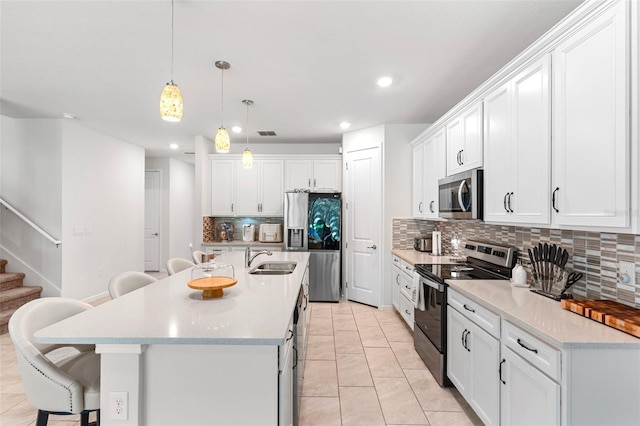 kitchen featuring a breakfast bar area, stainless steel appliances, and white cabinets