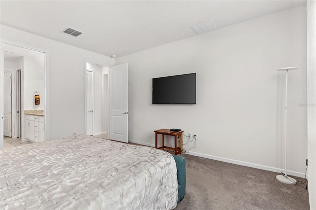 bedroom with connected bathroom and light colored carpet