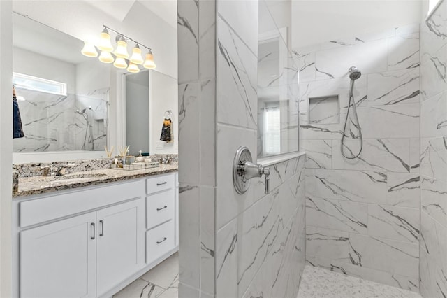 bathroom with vanity and a tile shower