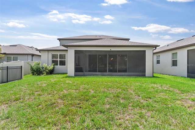 back of property featuring a sunroom and a lawn