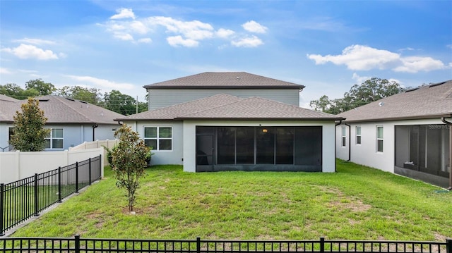 rear view of property featuring a sunroom and a yard