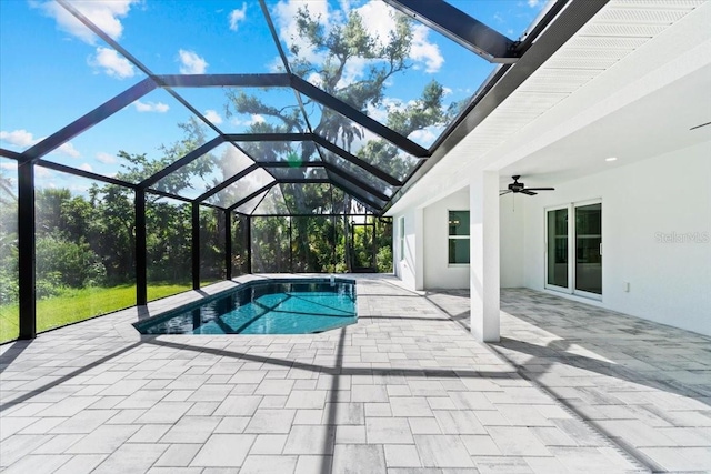 view of pool featuring glass enclosure, ceiling fan, and a patio