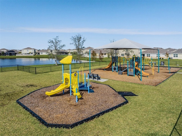 view of playground with a yard and a water view