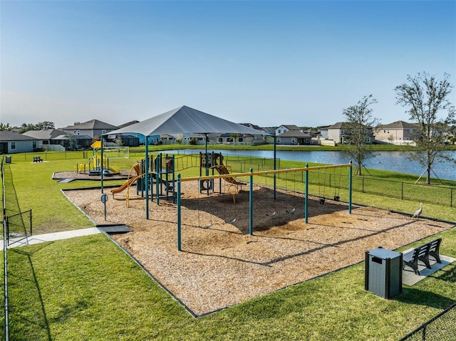 view of playground with a yard and a water view