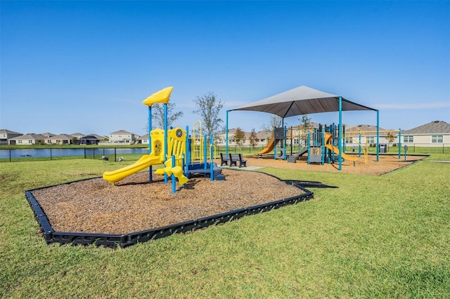 view of jungle gym featuring a water view and a lawn