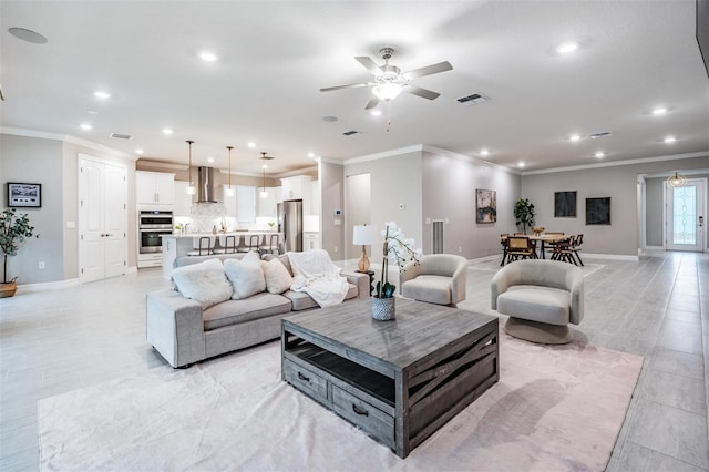 living room featuring ceiling fan and crown molding