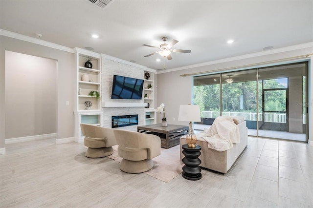 living room with ceiling fan, built in shelves, crown molding, and a fireplace