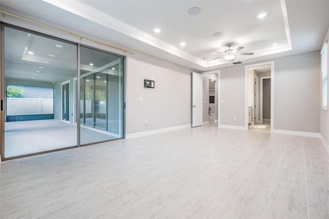 empty room with ceiling fan, crown molding, and a tray ceiling