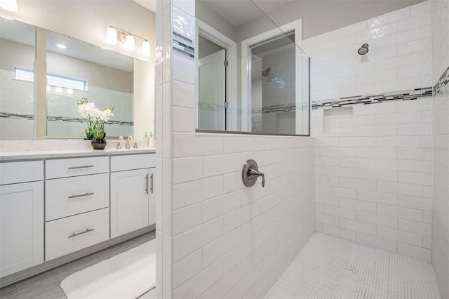 bathroom featuring vanity and tiled shower