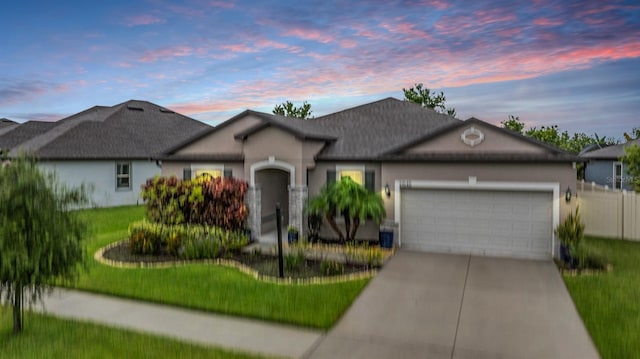 single story home with a garage and a lawn