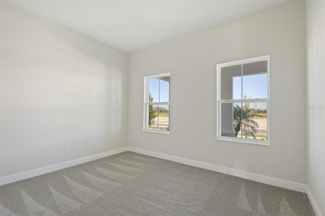 unfurnished room featuring carpet floors and baseboards