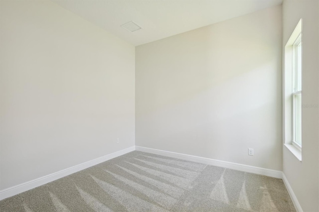 carpeted empty room featuring baseboards