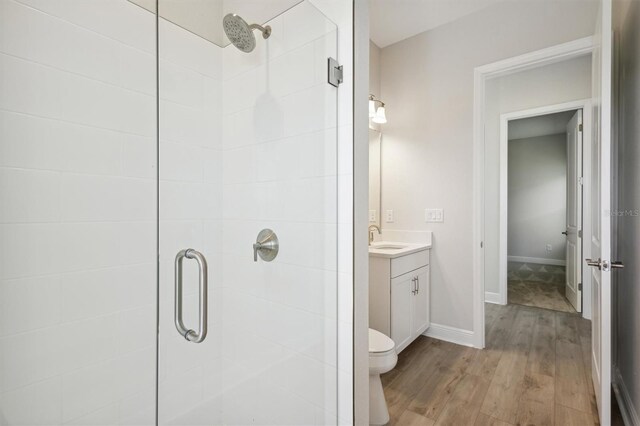full bath with vanity, wood finished floors, toilet, and a shower stall