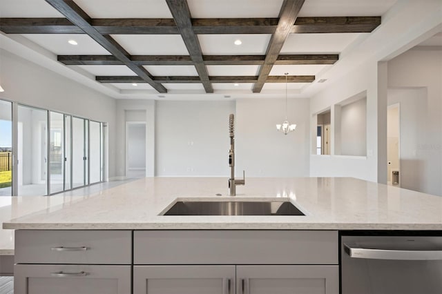 kitchen with stainless steel dishwasher, gray cabinets, light stone countertops, and an island with sink