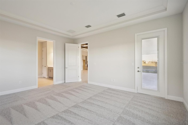 10426 Longmeadow Ave, Parrish, FL 34219 - unfurnished bedroom with light colored carpet, a tray ceiling, baseboards, and connected bathroom