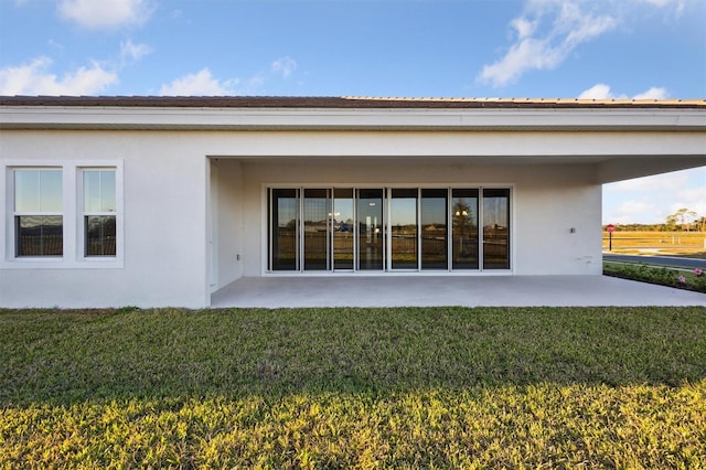 rear view of property with a lawn and a patio area