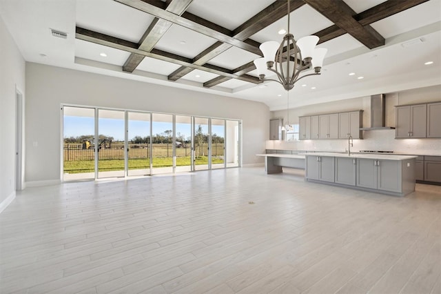 10324 Longmeadow Ave, Parrish, FL 34219 - unfurnished living room featuring beam ceiling, a chandelier, coffered ceiling, baseboards, and a sink