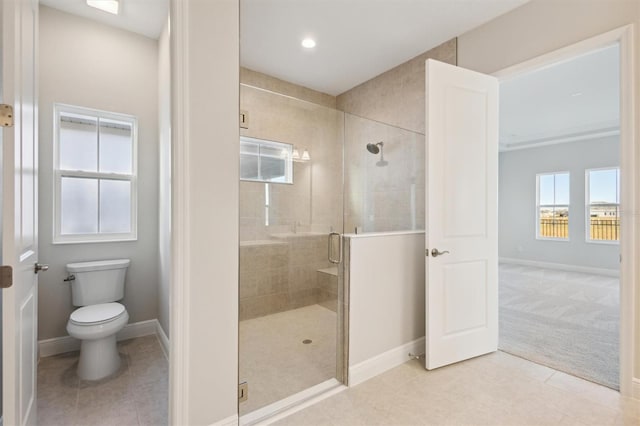 bathroom with tile patterned flooring, toilet, and a shower with shower door