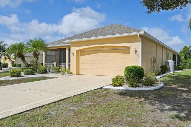 view of front of home with central air condition unit and a garage