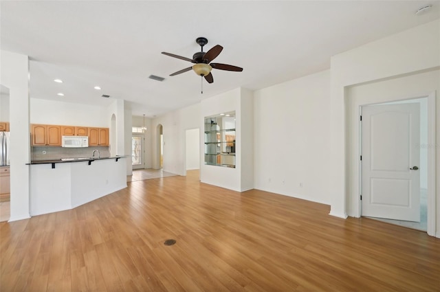 unfurnished living room with ceiling fan and light hardwood / wood-style floors