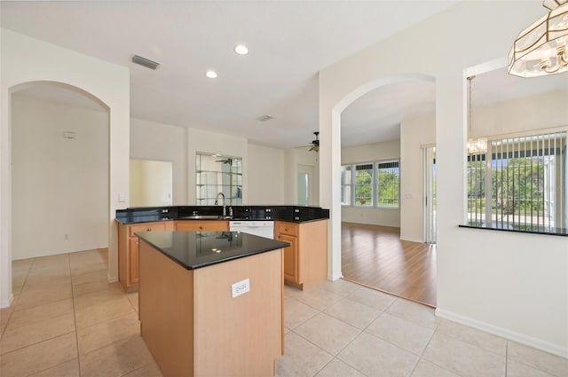 kitchen featuring dishwasher, ceiling fan with notable chandelier, sink, light tile patterned floors, and kitchen peninsula