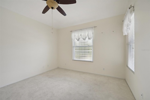 empty room featuring light carpet, plenty of natural light, and ceiling fan