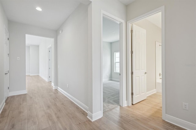 hallway with light hardwood / wood-style floors