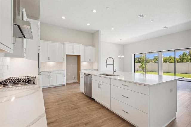 kitchen with an island with sink, light hardwood / wood-style flooring, stainless steel appliances, and white cabinets