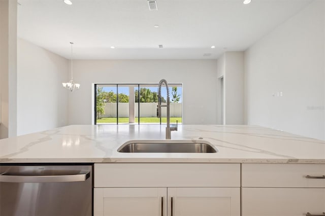 kitchen featuring dishwasher, light stone counters, a chandelier, and sink