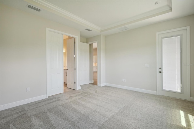 unfurnished bedroom featuring a tray ceiling and light carpet