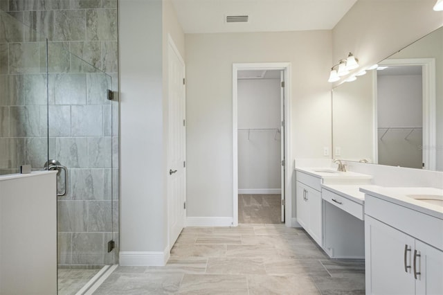 bathroom with a shower with door and vanity