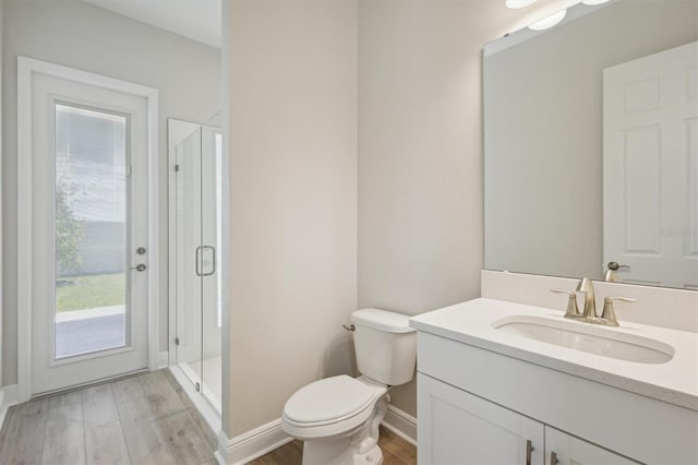 bathroom with vanity, toilet, hardwood / wood-style floors, and walk in shower