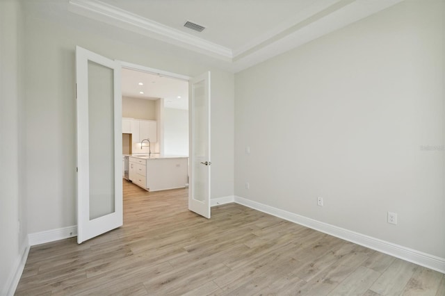 unfurnished bedroom featuring crown molding, sink, and light wood-type flooring