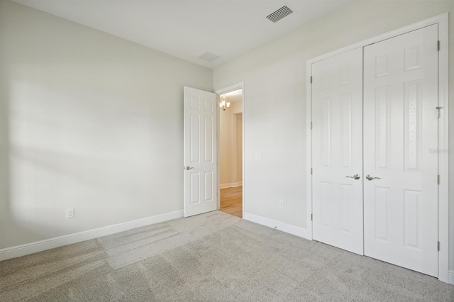 unfurnished bedroom featuring a closet and light carpet