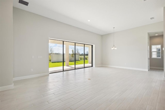 unfurnished room featuring an inviting chandelier and light wood-type flooring