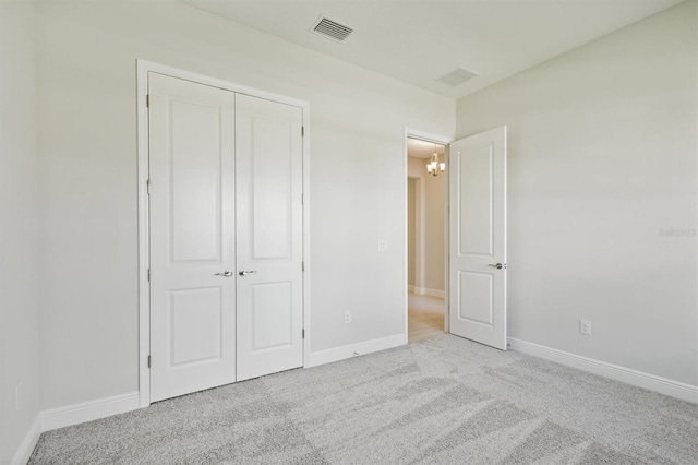 unfurnished bedroom featuring a closet and light colored carpet