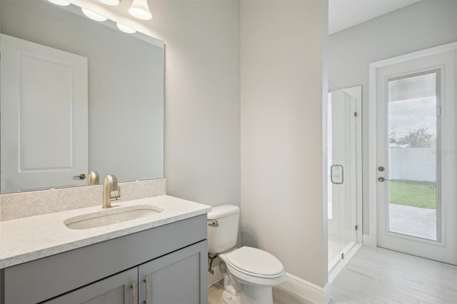 bathroom with vanity, toilet, hardwood / wood-style flooring, and a shower with shower door