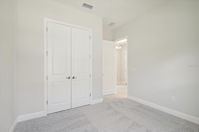 unfurnished bedroom featuring a closet and light carpet