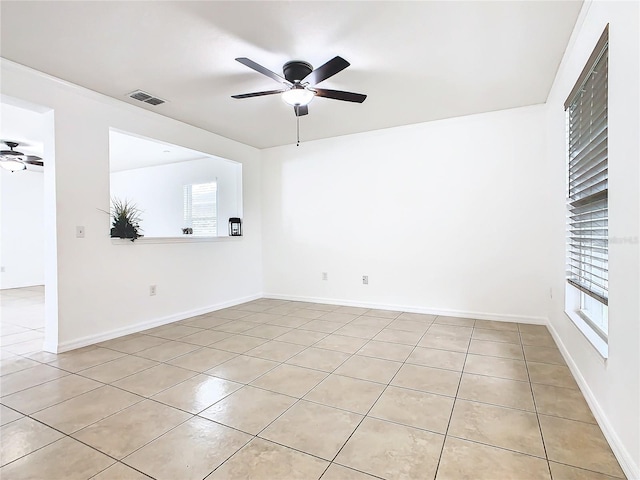 tiled spare room featuring ceiling fan