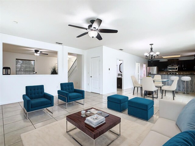 living room with ceiling fan with notable chandelier and tile patterned floors