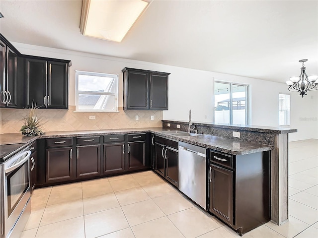 kitchen featuring a notable chandelier, appliances with stainless steel finishes, tasteful backsplash, hanging light fixtures, and sink