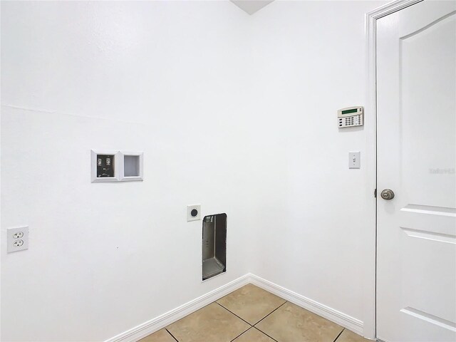 clothes washing area featuring electric dryer hookup and light tile patterned floors