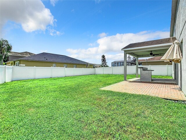 view of yard with ceiling fan and a patio