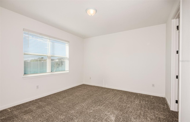 unfurnished room with dark carpet