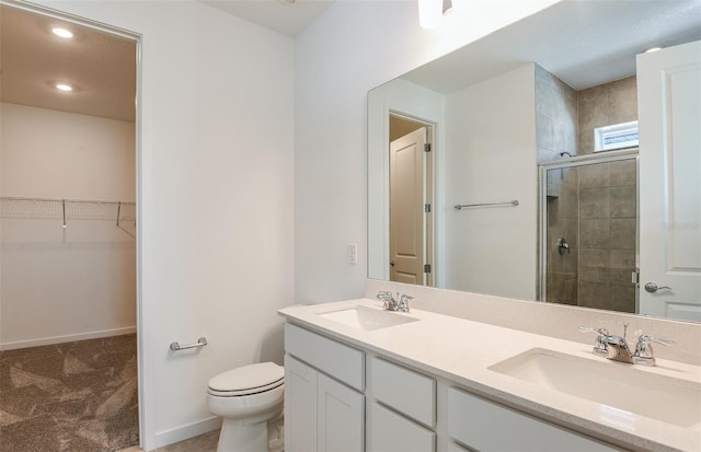 bathroom featuring toilet, walk in shower, and vanity