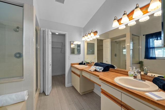 2618 Crestfield Dr, Valrico, FL 33596 - full bath featuring a shower stall, double vanity, vaulted ceiling, wood finished floors, and a spacious closet