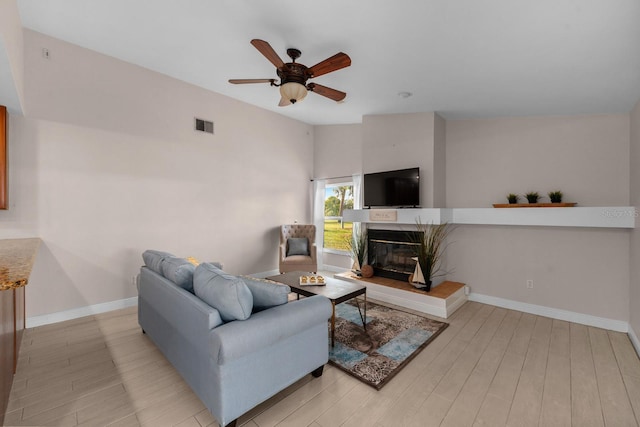 2618 Crestfield Dr, Valrico, FL 33596 - living room featuring light wood-style flooring, ceiling fan, a fireplace, and baseboards
