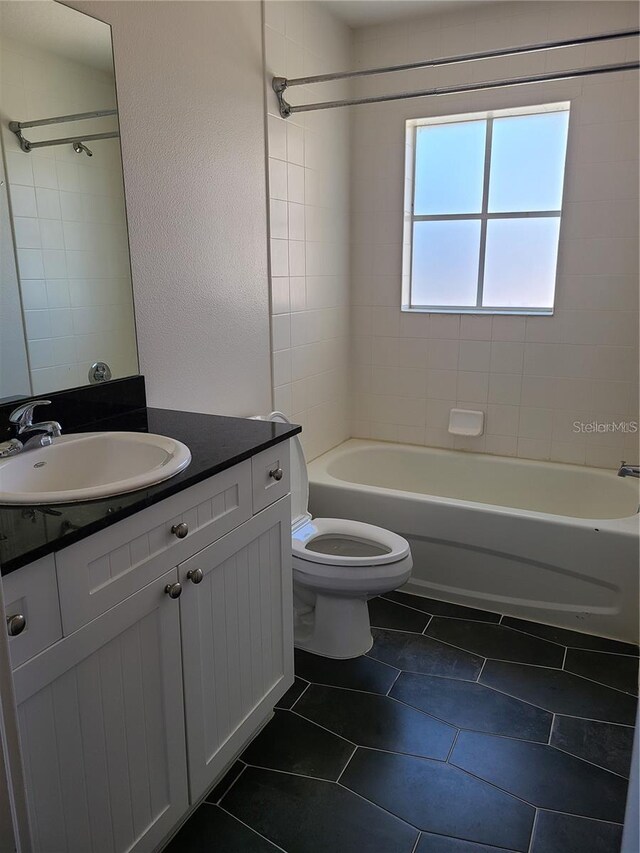 full bathroom with tile patterned floors, toilet, vanity, and tiled shower / bath