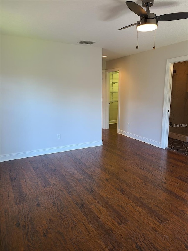 spare room featuring dark wood-type flooring and ceiling fan